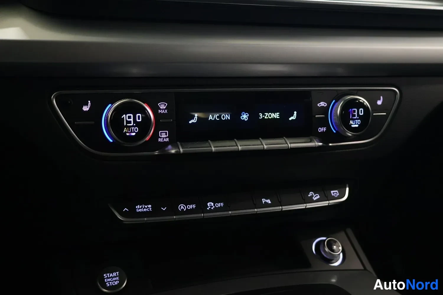 Yksityiskohta: Auton keskikonsoli: kaksivyöhykeilmastointi (3-ZONE, A/C ON, molemmat puolet 19,0 astetta AUTO), alla painikkeet drive select, OFF-kytkimiä, pysäköintiautomaati