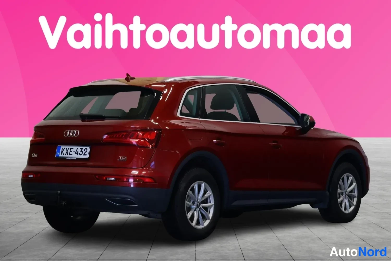 Takaviisto: Audi Q5 -maasturin takaosan kolmen neljäsosan näkymä, tummanpunainen kori, rekisterikilpi.