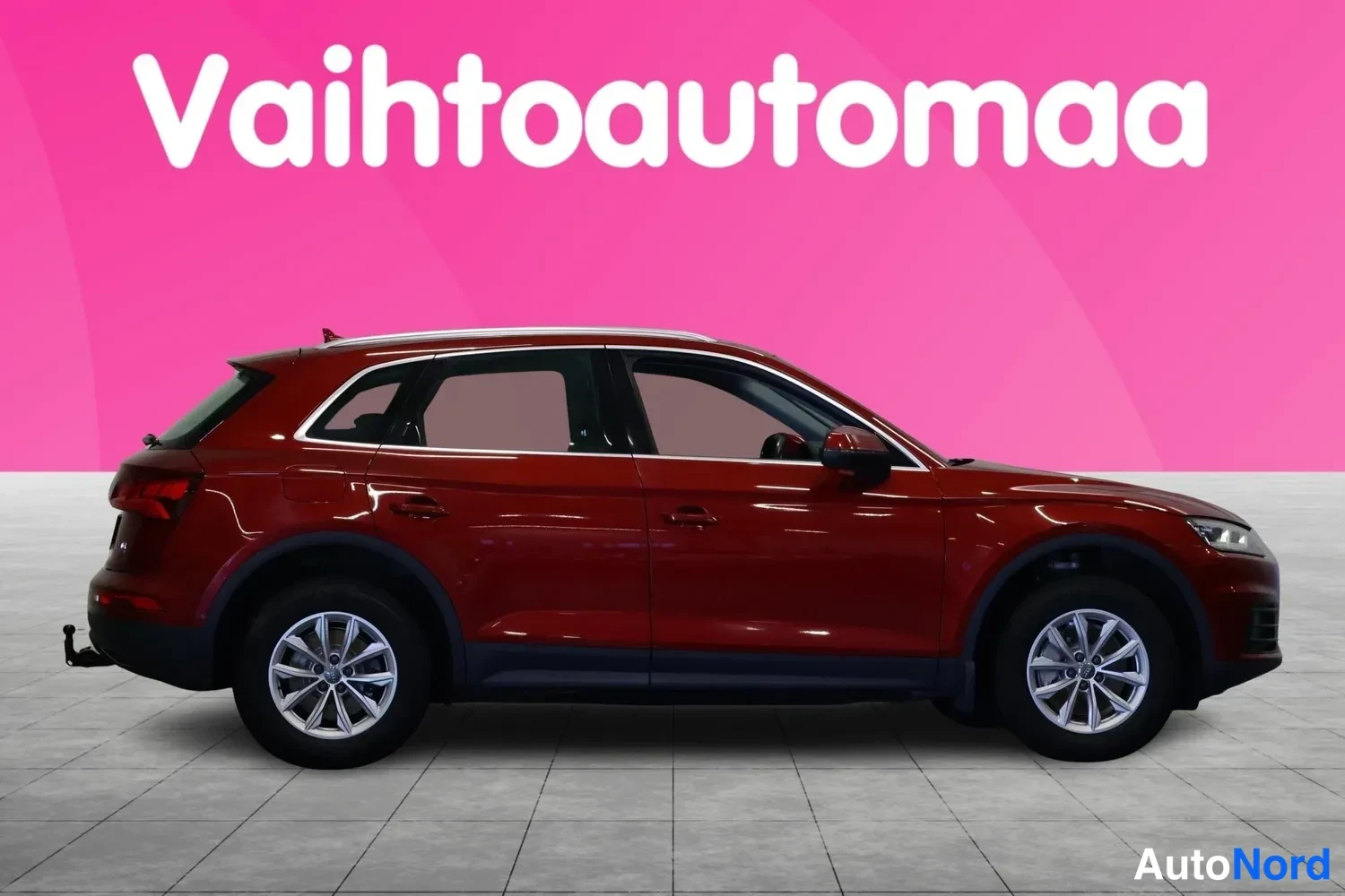 Sivulta: Audi Q5 -maasturin sivunäkymä, tummanpunainen kori ja hopeiset kevytmetallivanteet.