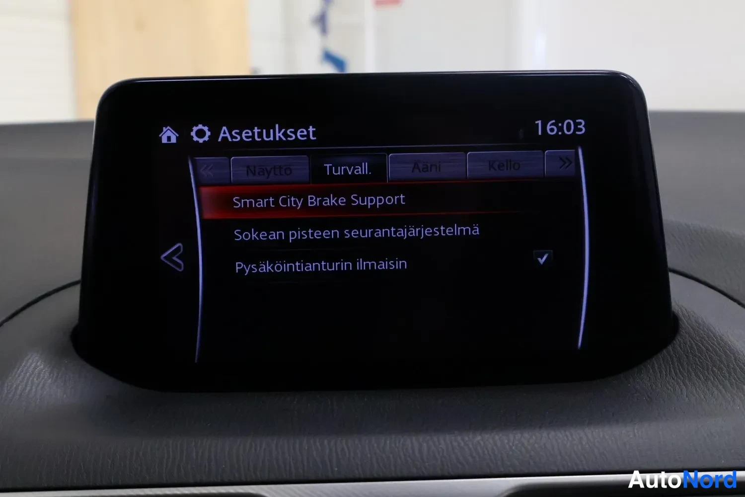 Sivulta: Auton kojelaudassa nostettava infotainment-näyttö, jonka asetusvalikossa on turvallisuusosoikeudet: Smart City Brake Support, sokean pisteen seurantajärjestelmä