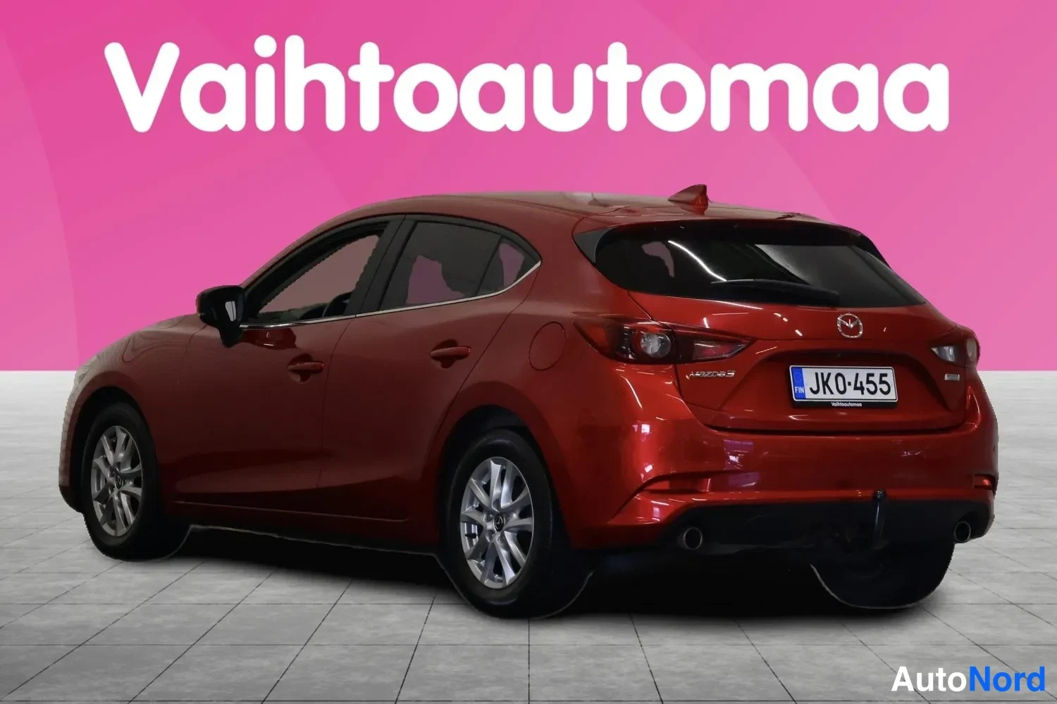 Takaviisto: Punaisen Mazda3-hatchbackin takakulmanäyttö vasemmalta takaa, rekisterikilpi JK0-455.