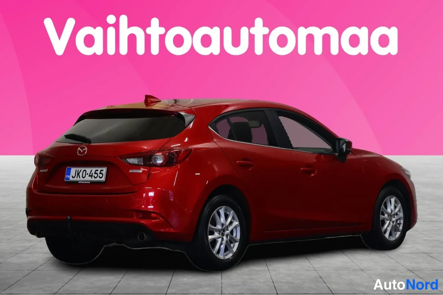 Takaviisto: Punaisen Mazda3-hatchbackin takakulmanäyttö vasemmalta takaa, rekisterikilpi JK0-455.