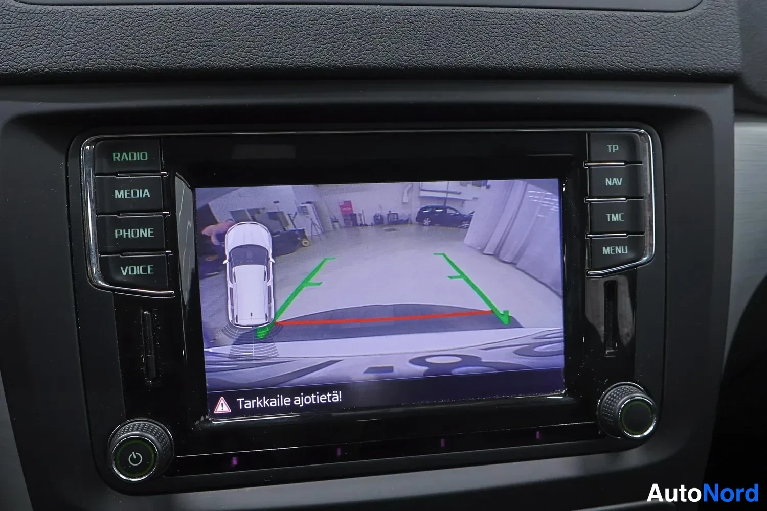 Etuviisto, nokka oikealle: Rearview camera display showing guidelines overlay while reversing.