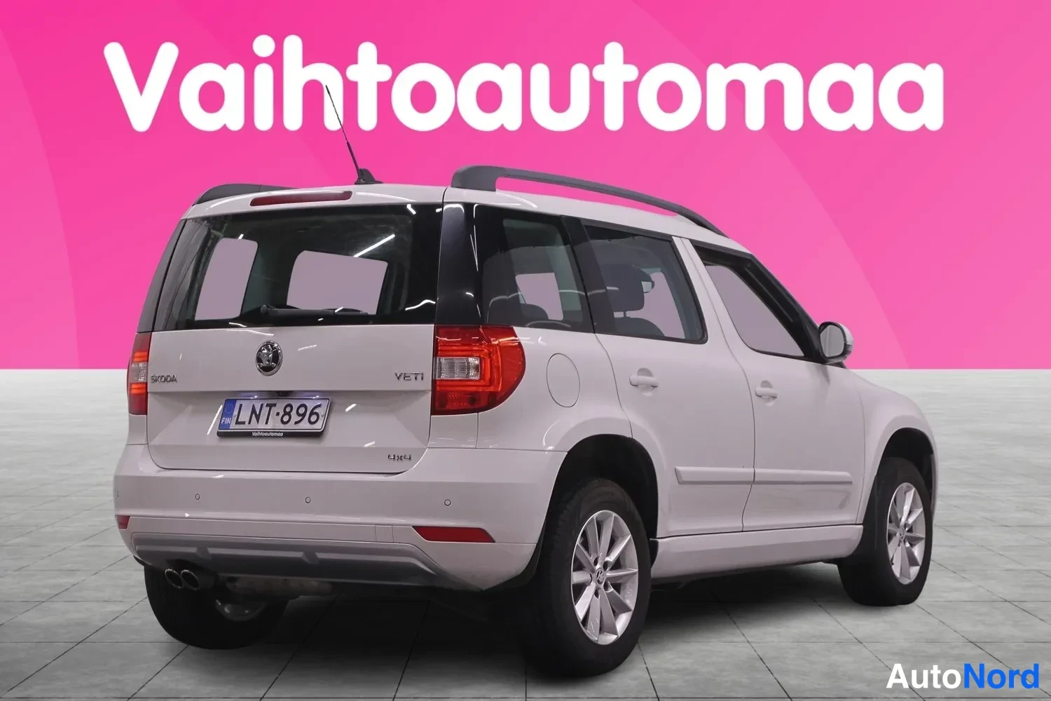 Takaviisto: Valkoisen Skoda Yetin takaosa ja vasen kylki kolmen neljäsosan kulmasta; rekisterikilpi, kattokaiteet ja takavalojen punainen valaisin.