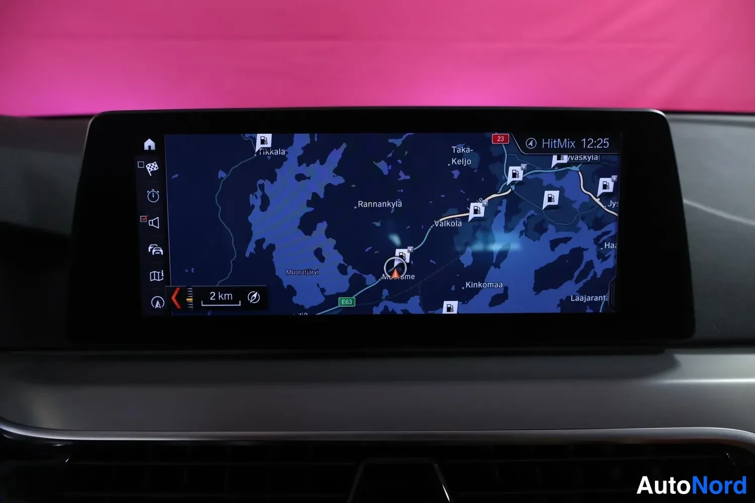 Muu: Kojelaudan keskellä oleva infotainment-näyttö näyttää navigointikarttaa tekstillä HitMix, kello 12:25 ja etäisyys 2 km.
