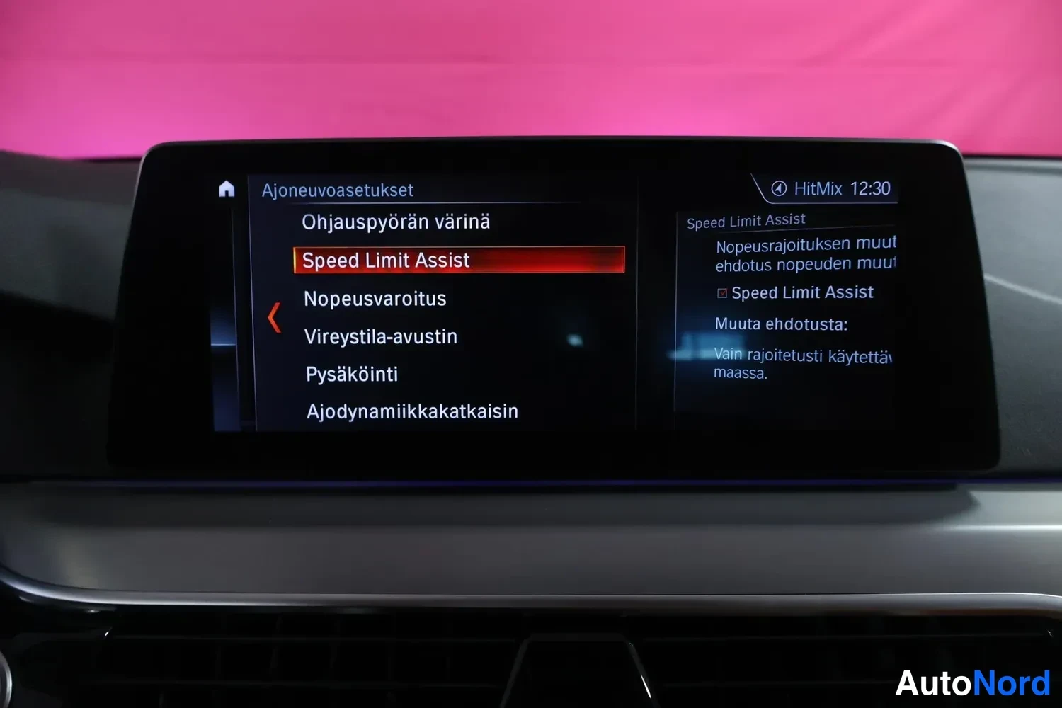 Yksityiskohta: Autoon rakennettu infotainment-näyttö, jossa on auki Ajoneuvoasetukset-valikko ja Speed Limit Assist korostettuna.