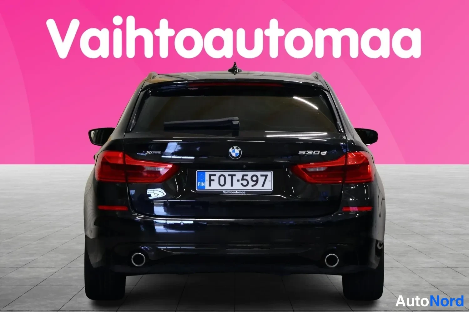 Takaa: Mustan BMW:n takaosa suoraan takaa, rekisterikilpi ja takaosan kirjaimet.