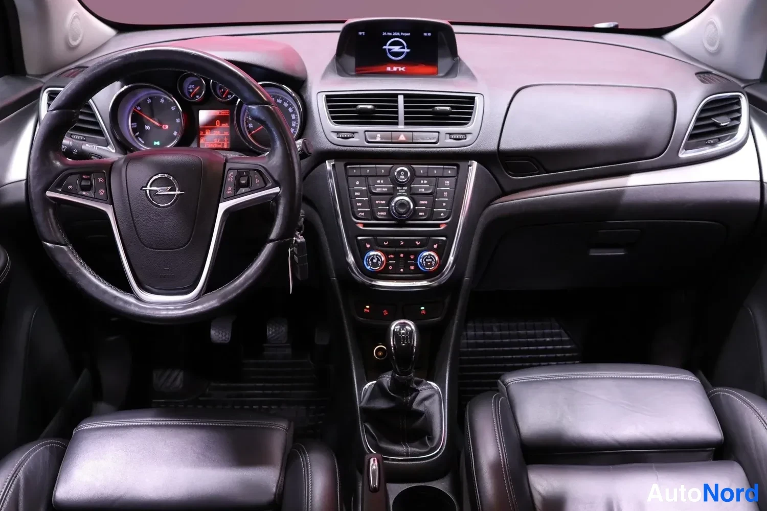 Muu: Kojelauta edestä: Opel-ohjauspyörä, analogiset mittarit, keskikonsolin radio ja manuaalivaihteen keila, näyttö kojelaudan yläosassa.