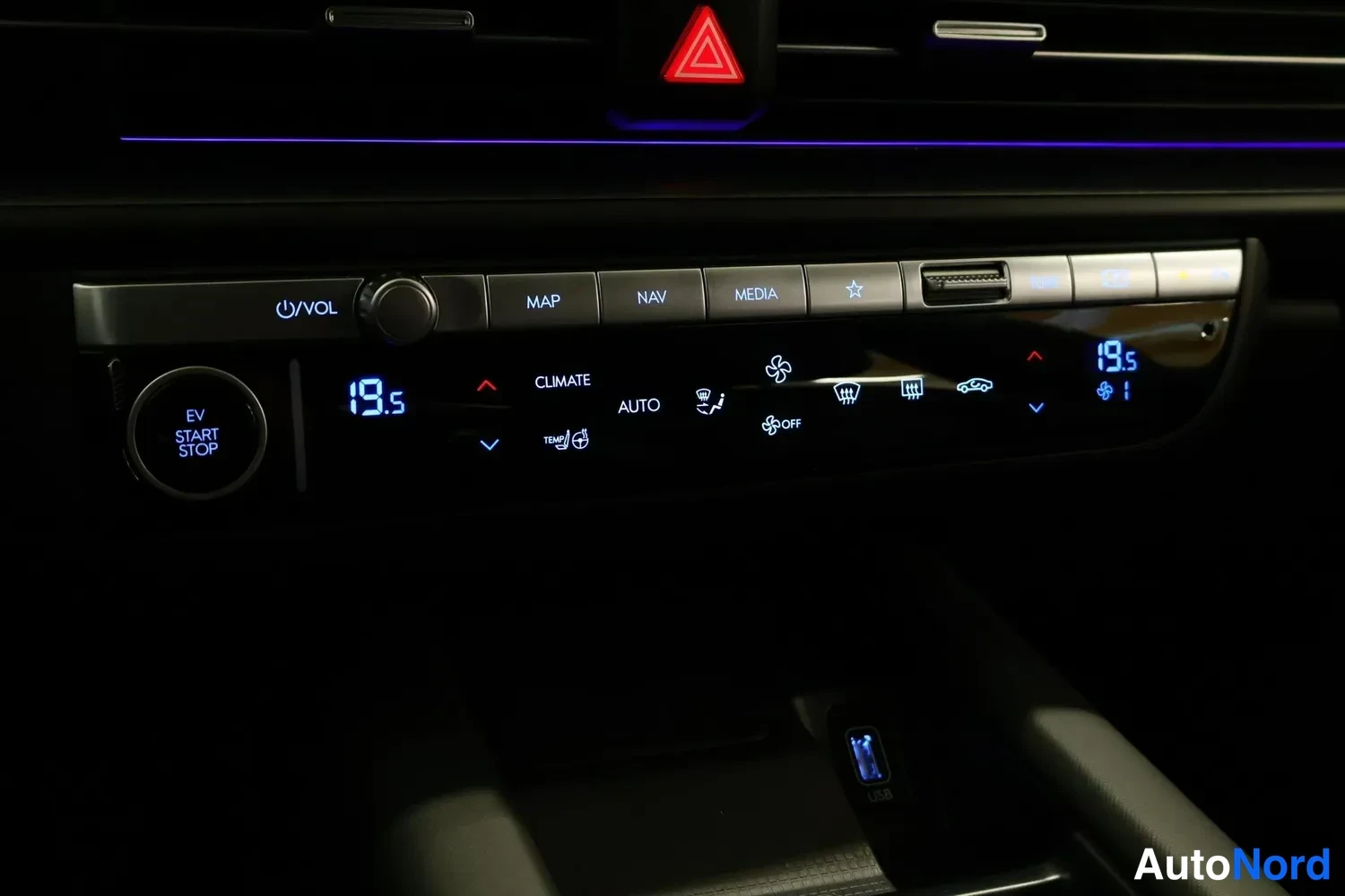 Muu: Keskikonsolin lämmityspaneeli näyttää 19,5 astetta, EV START STOP -painike ja heated steering wheel -kuvake.