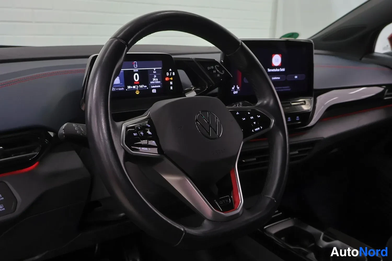 Muu: Volkswagen ID.4 GTX:n ohjaamo: GTX-ohjauspyörä, digitaalinen mittaristo näyttää 167 km toimimaton hetkialukset ja keskikonsolin infotainmentnäyttö.