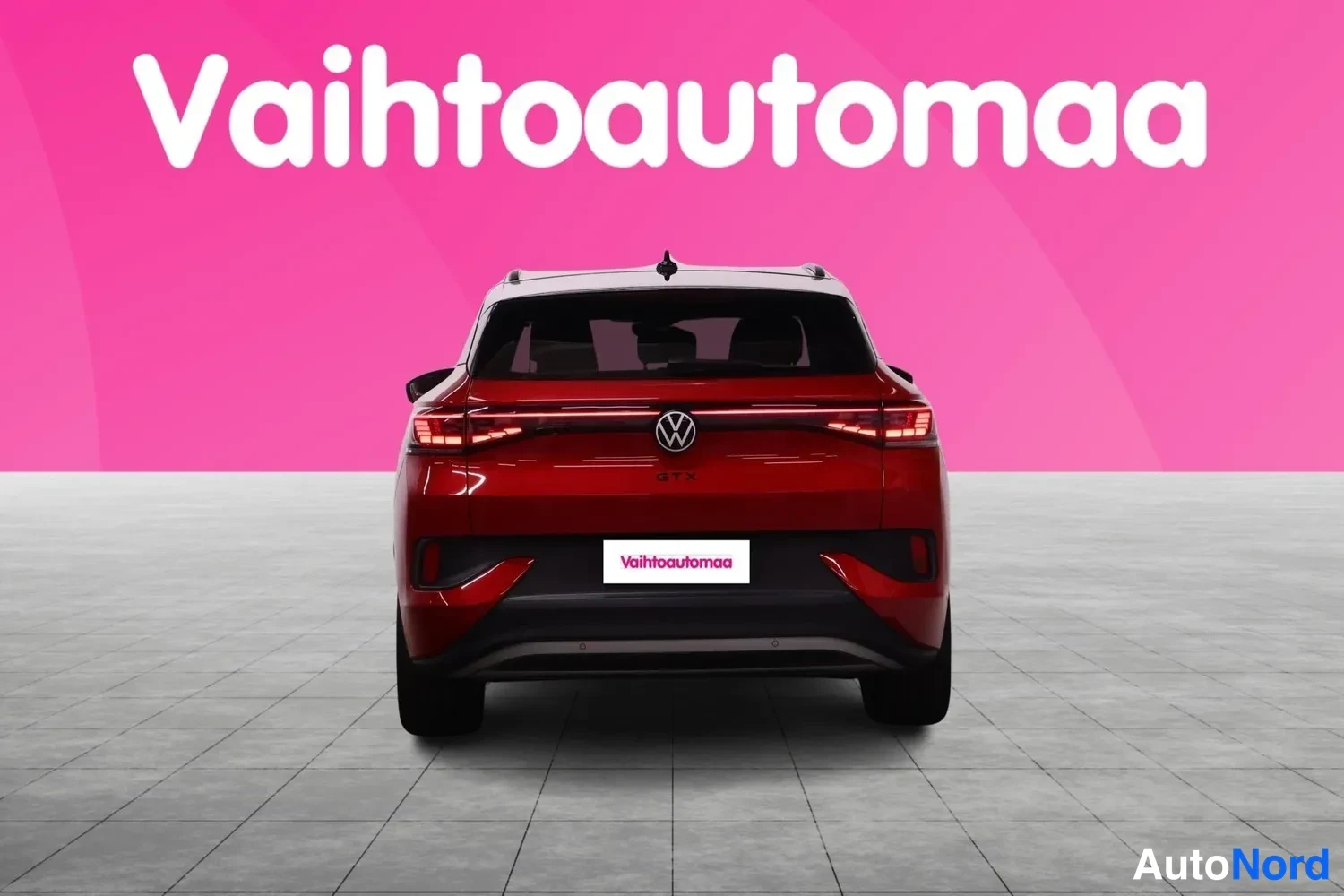 Takaa: Punainen Volkswagen suoraan takaa, LED-takavalot ja musta lasikatto, Vahtoautomaa-tunnuksella