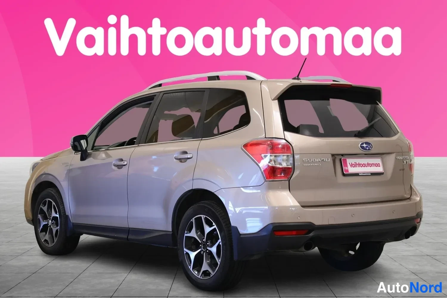 Takaviisto: Beige tila-auto takaosasta vasemmasta sivusta kuvattuna, SUBARU-merkintä takaluukussa, kattoteline ja kevytmetallivanteet.