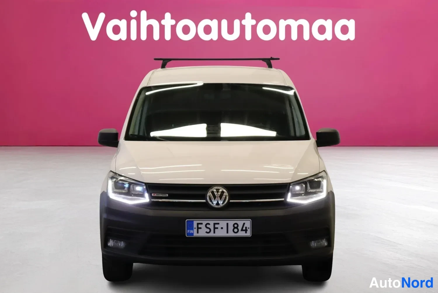 Edestä: Valkoinen pakettiauto suoraan edestä, rekisteritunnus.