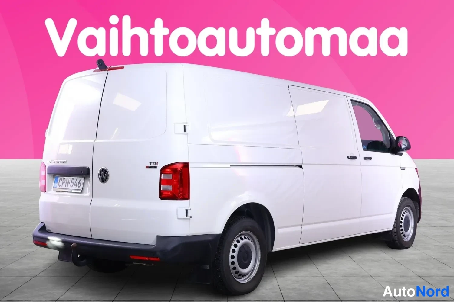 Takaviisto: Valkoinen pakettiauto takaa viistosta oikealta, kylkiovi ja takaosa näkyvissä.