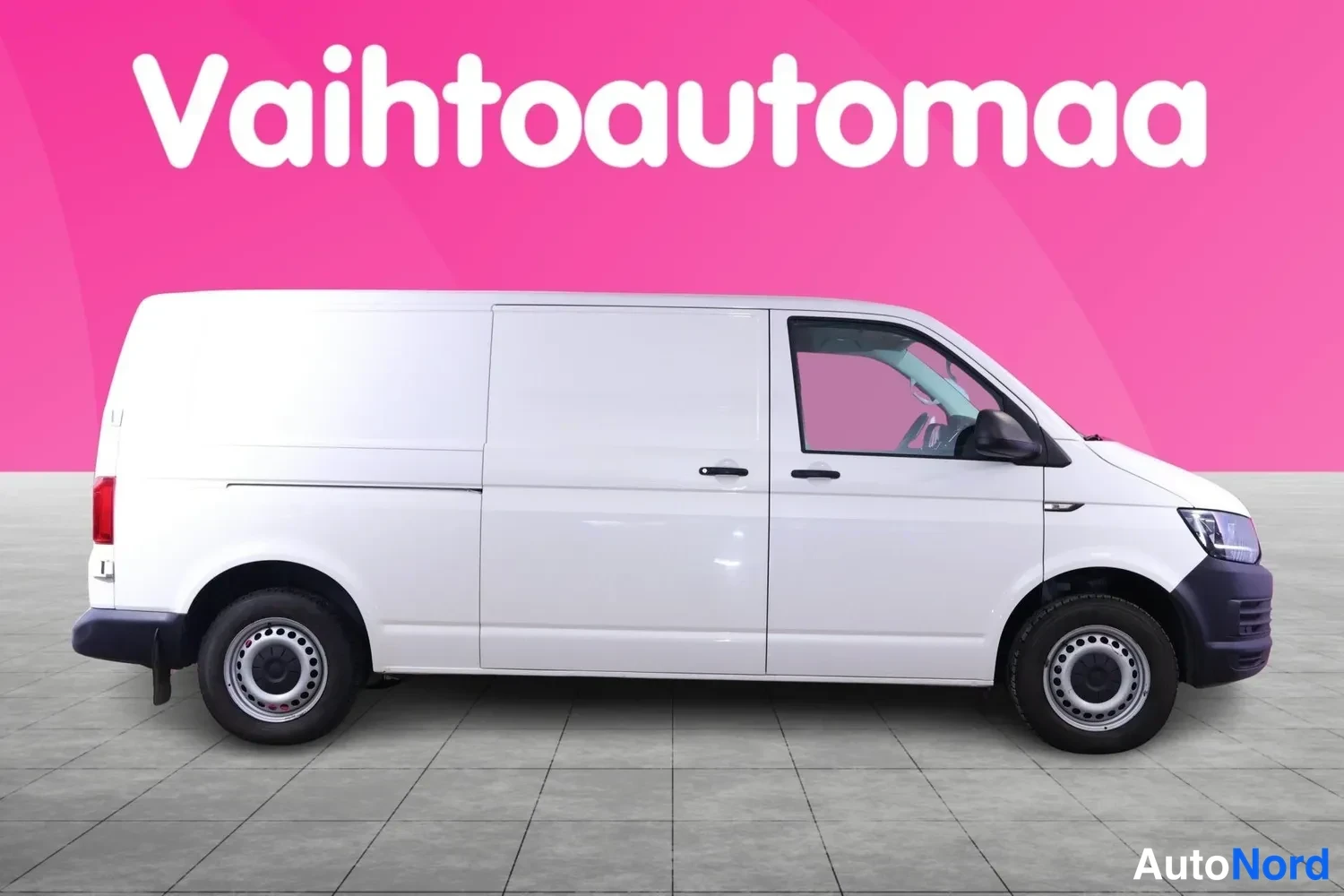 Etuviisto, nokka oikealle: Valkoinen pakettiauto sivusta viistosta etupää oikealla, liukuovi ja etuosa näkyvissä.