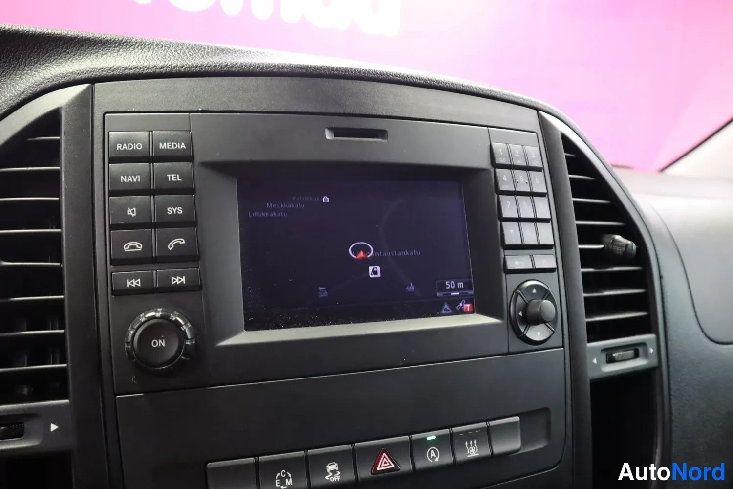 Muu: kojelaudan infotainment-näyttö näyttää navigointikarttaa, ympärillä RADIO-, MEDIA-, NAVI-, TEL- ja SYS-näppäimet