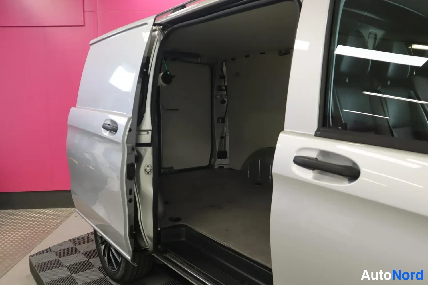 Sivulta: Sivukuva hopeanvärisestä pakettiautosta, jonka liukuovet ovat auki ja tyhjä kuormatila näkyy.