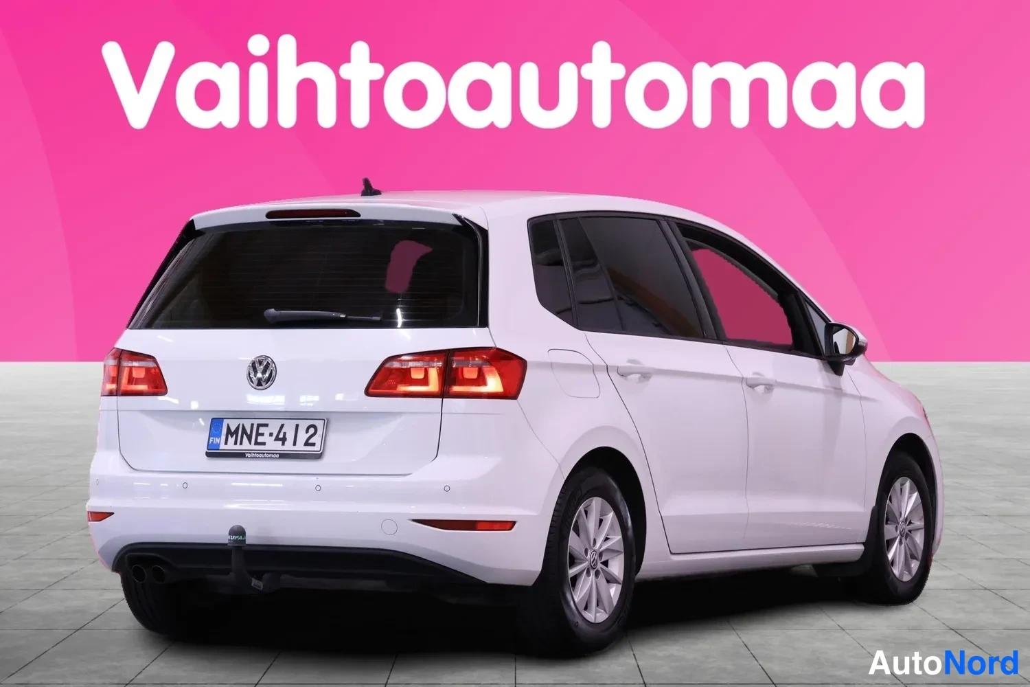 Takaviisto: Valkoinen Volkswagen Golf Sportsvan takaosa viistosti oikealta, rekisteri ja vetoaisa.