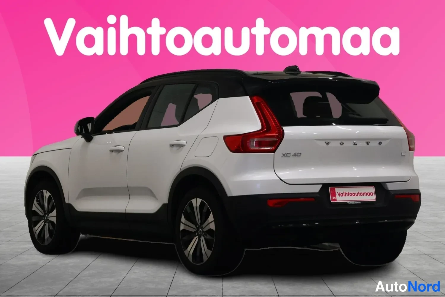 Takaviisto: Valkoinen Volvo XC40 takakulmasta; takaluukussa VOLVO- ja XC40-tekstit, punaiset takavalot ja Vaihtoautomaa-tekstinen rekisterikilven kehys.