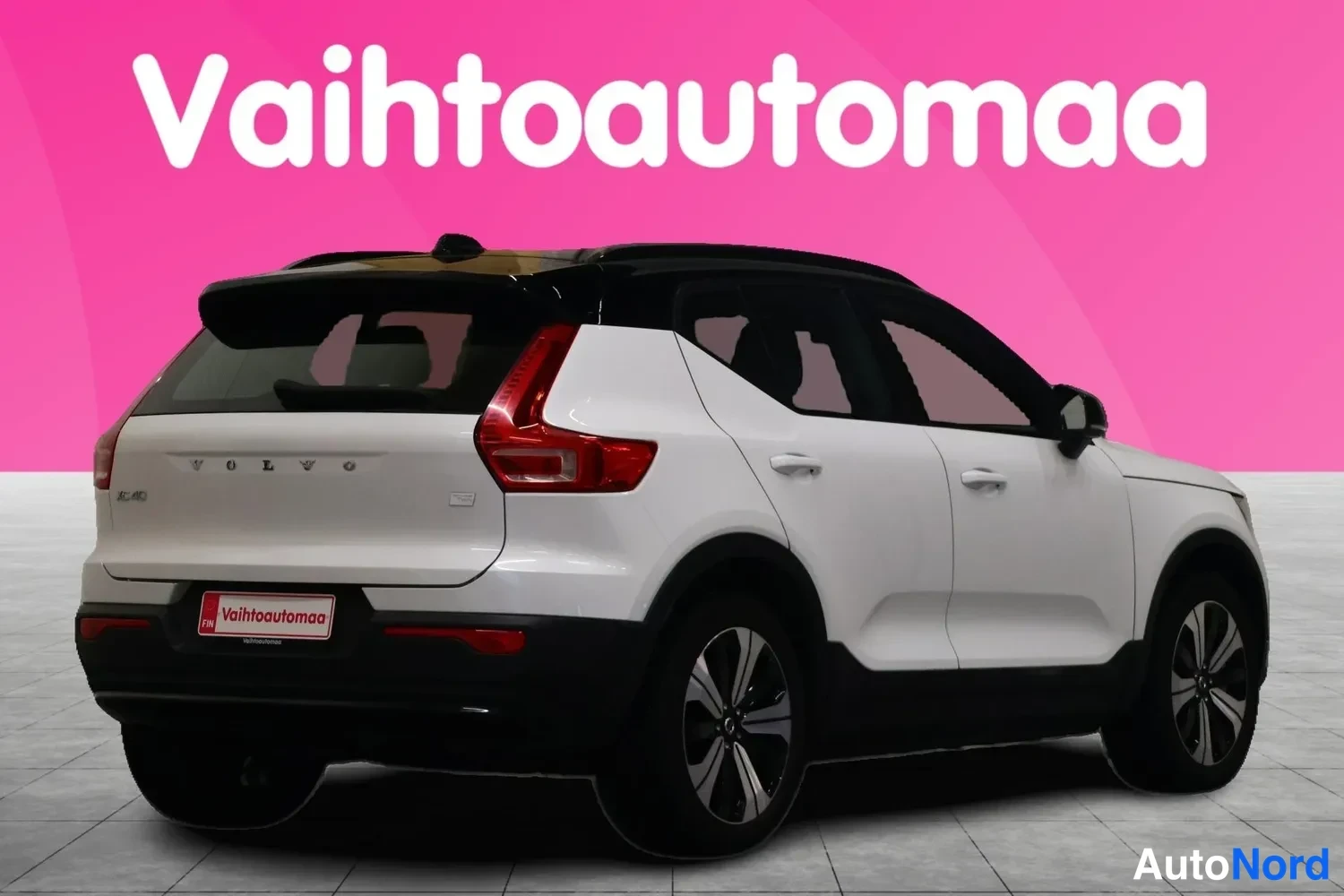 Takaviisto: Valkoinen Volvo XC40 takakulmasta oikealta; takaluukun VOLVO-teksti ja punaiset takavalot näkyvissä.