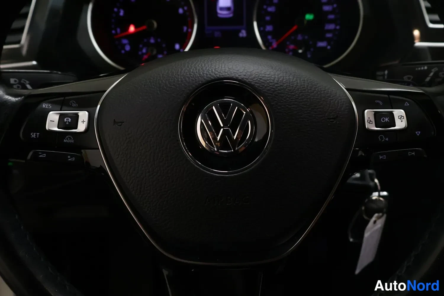 Muu: VW-merkkiohjauspyörä ja risteilijäohjauksen RES/SET-painikkeet, taustalla kojelaudan mittarit.