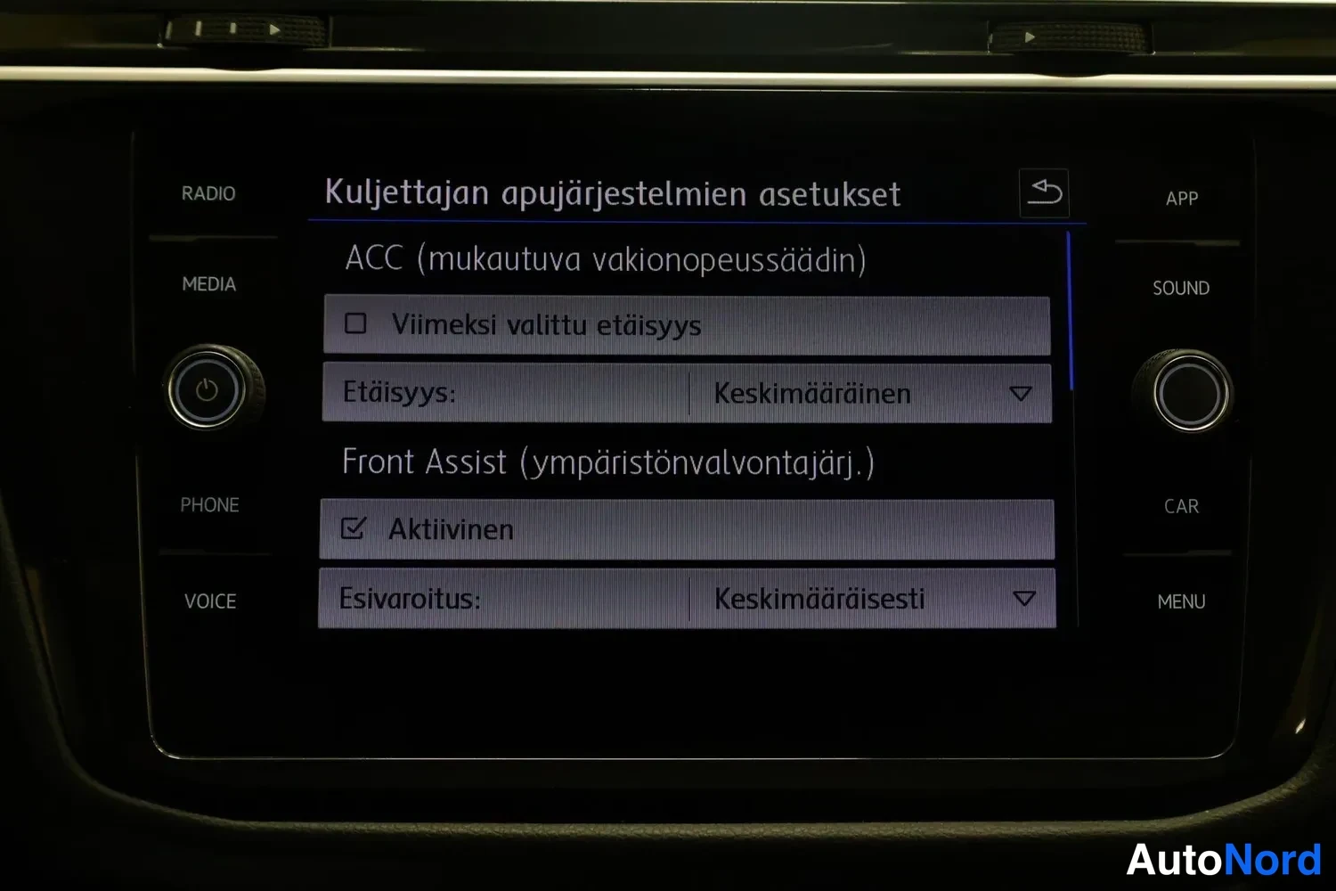 Yksityiskohta: Viihdejärjestelmän näyttö: valikossa Kuljettajan apujärjestelmien asetukset, kohtana ACC (mukautuva vakionopeussäädin) ja Front Assist (ympäristönvalvontajärj.)