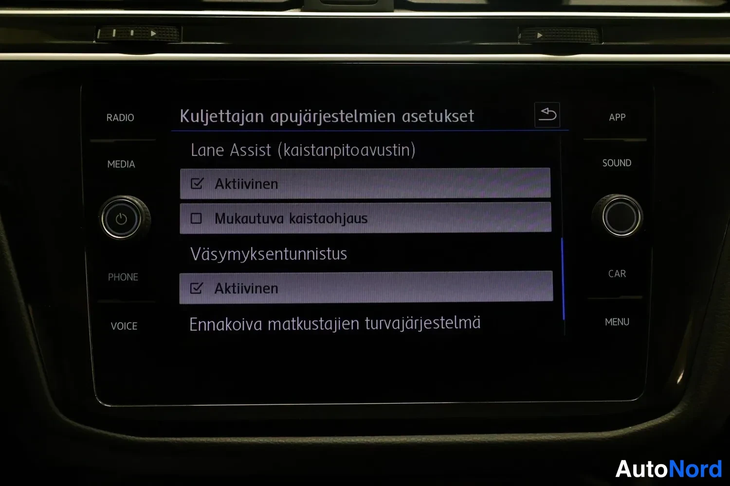 Yksityiskohta: Viihdejärjestelmän näyttö: valikossa Kuljettajan apujärjestelmien asetukset, kohtana Lane Assist (kaistanpitoavustin), Mukautuva kaistaohjaus, Väsymyksentunnist