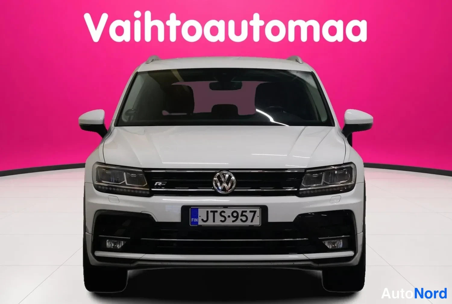 Edestä: Valkoinen Volkswagen Tiguan suoraan edestä, keula kohti katselijaa, rekisteritunnus.