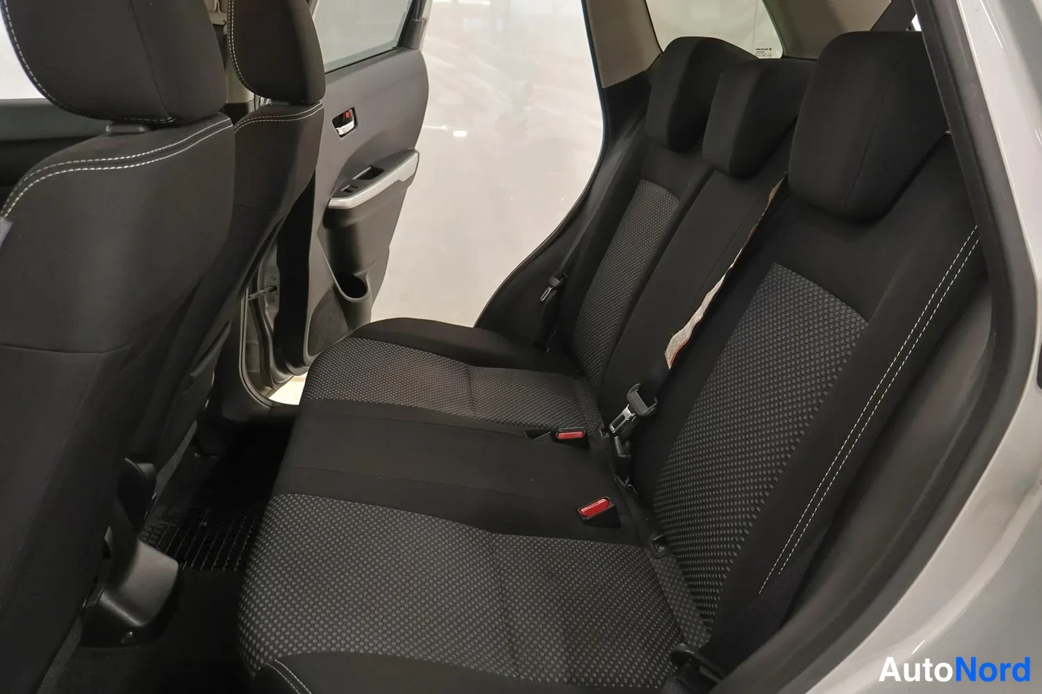 Muu: Suzukin takapenkku sisäpuolelta, musta kangasverhoilu ja kolme niskatukea.