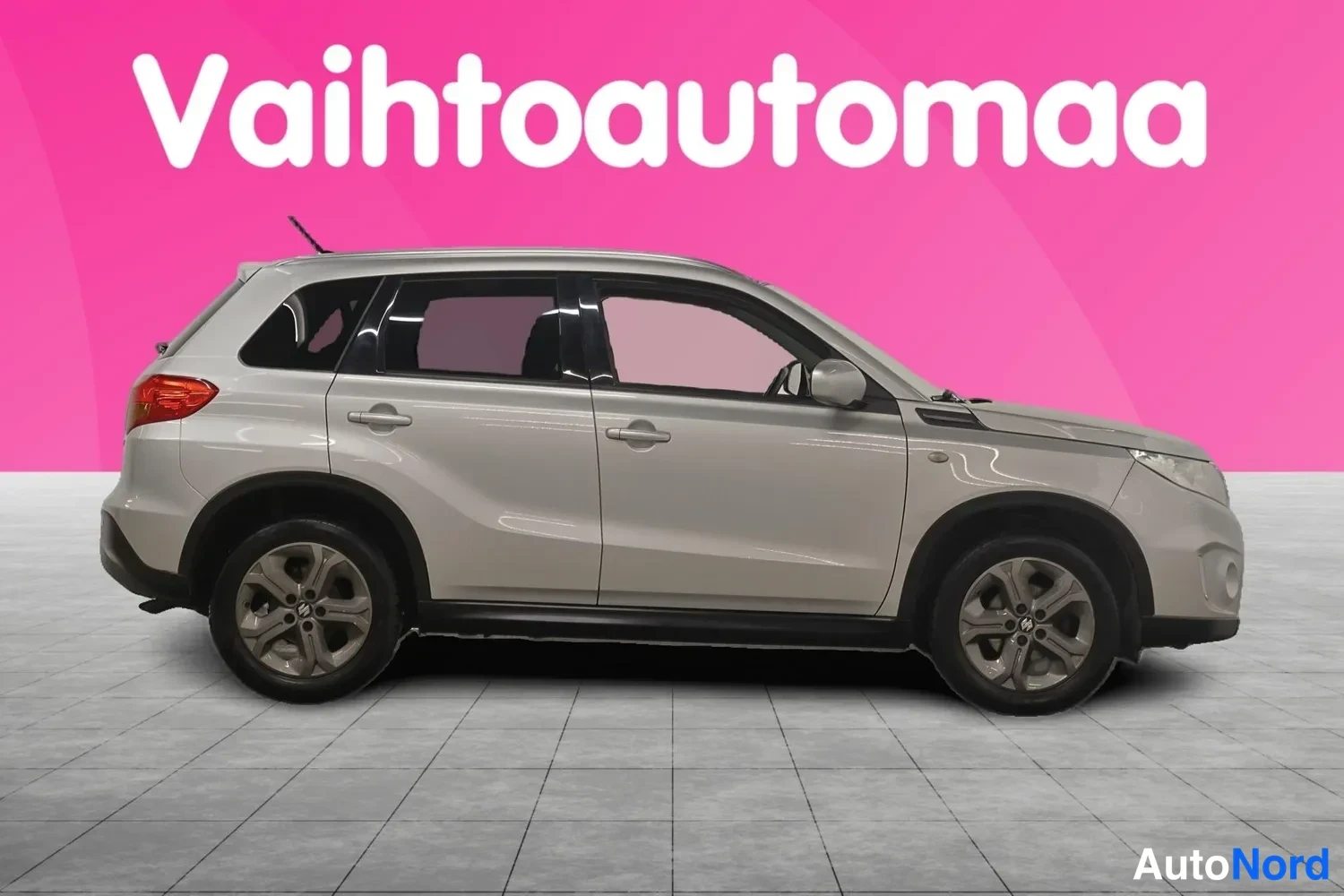 Etuviisto, nokka oikealle: Auton oikea sivu profiilissa: hopeanharmaa viisiovinen SUV, jonka keulavalot erottuvat kuvan oikeassa reunassa; pyörät ja ovenkahvat näkyvät selvästi.