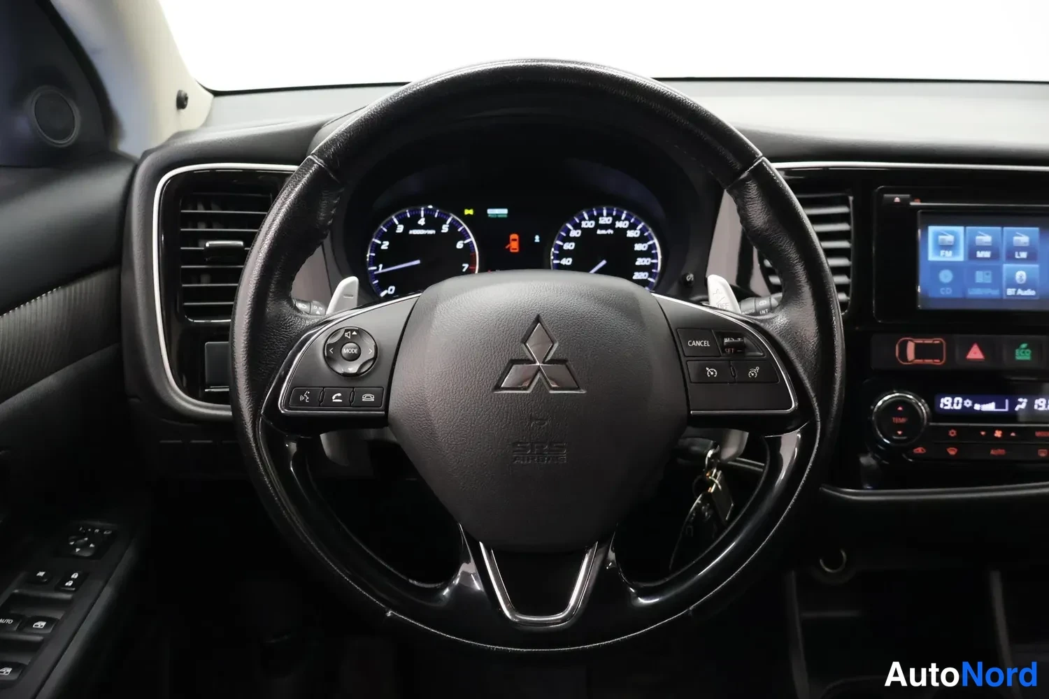 Muu: Ohjaamosta että on Mitsubishi-logoilla varustettu rattoinen ratto-osasto, kojelauta ja mittarit näkyvät.