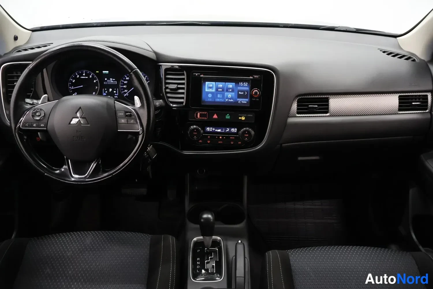 Edestä: Ohjaamo Mitsubishi Outlander: mittaristo, monitoimiohjaus, kosketusnäytöllinen radio ja automaattivaihteen valitsin.