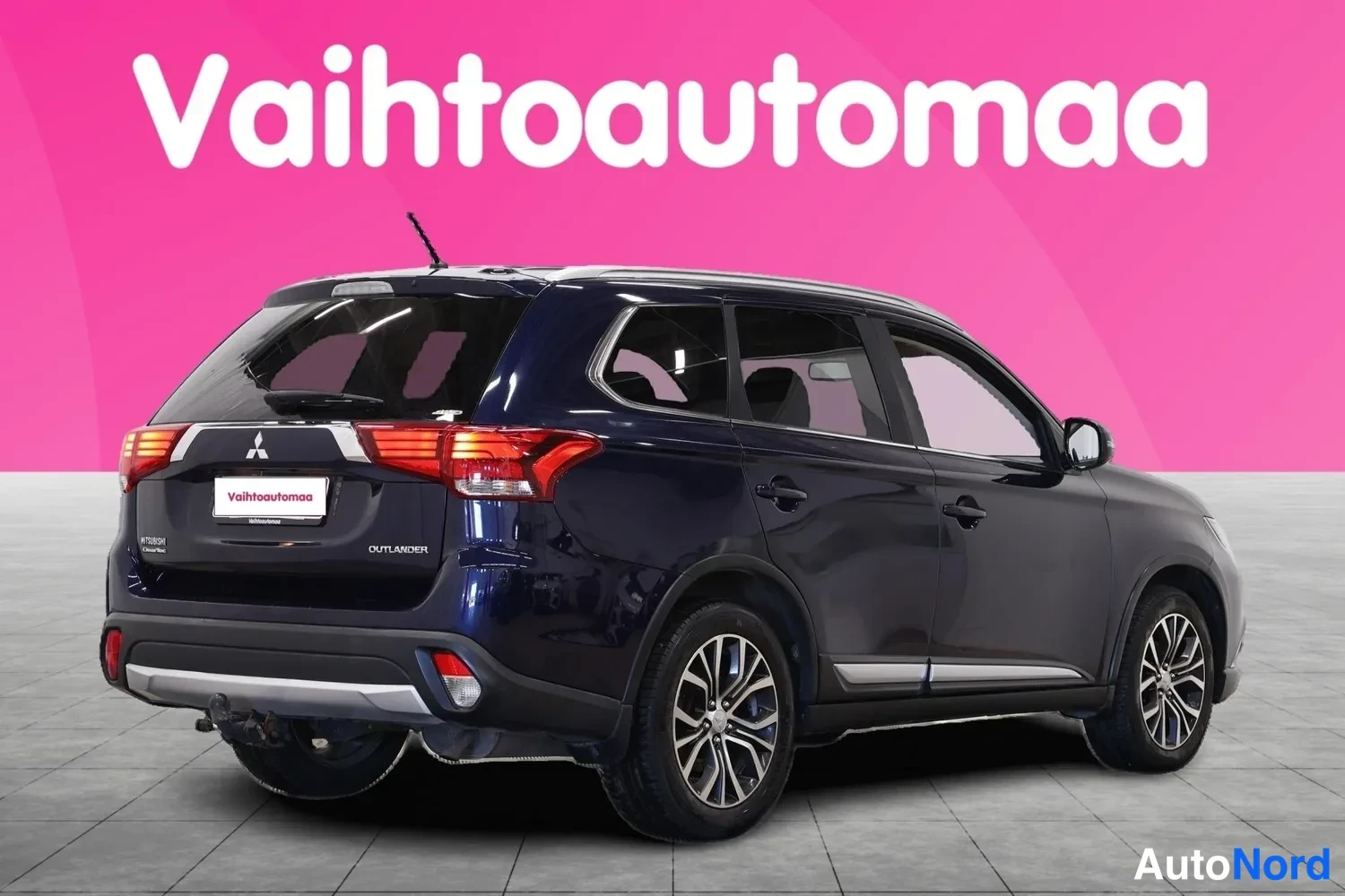 Takaviisto: Tummaa sinisen ruaan SUV:n takapää ja oikea sivu kolmesivukulmassa, takavalot ja keräilivät pyörät näkyvät.
