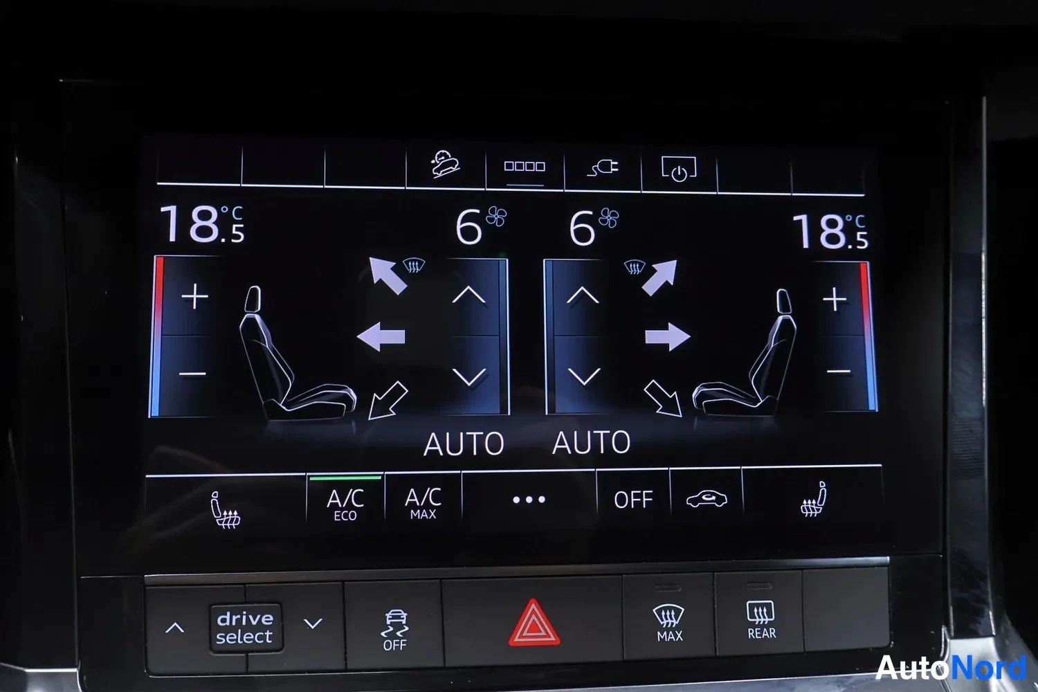 Muu: Auton ilmastointilaitteen näyttö, molempien puolen lämpötila 18,5 °C, puhallusaste 6, AUTO-toiminta, A/C ECO- ja A/C MAX-napit sekä drive select -painike ja var