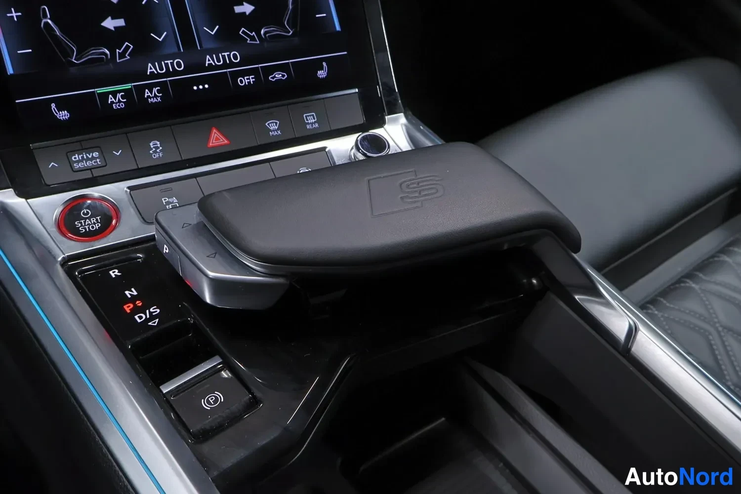 Muu: Keskikonsolin lähikuva: ilmastoinnin kosketusnäyttö (AUTO, A/C ECO, A/C MAX, OFF), drive select -painike, punainen START/STOP-painike, vaihteenvalitsin (R, N, P