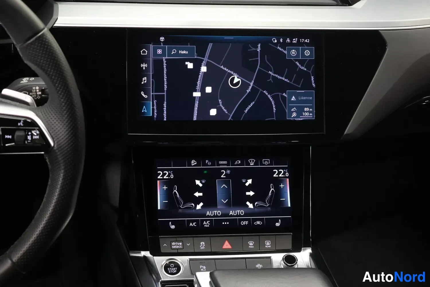Muu: Kojelaudan näkymä: ylhäällä infotainment-näyttö kartta- ja navigaationäkymällä, alhaalla kaksivyöhykeilmastointipaneeli (22,0 °C molemmin puolin, A/C ja AUTO-va