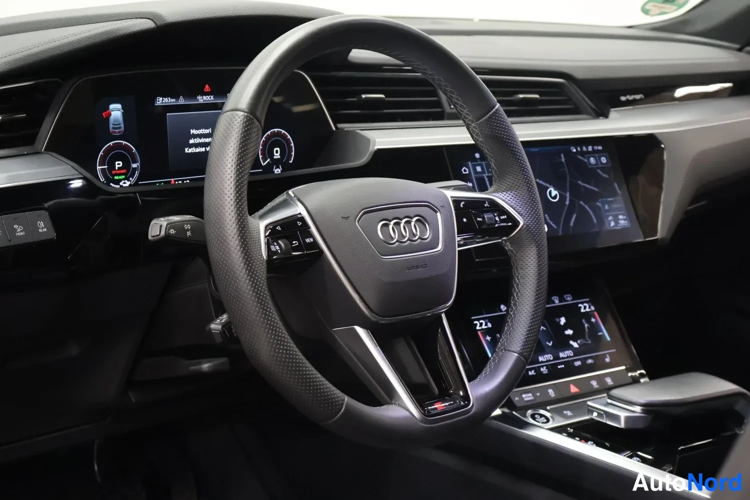 Muu: Autojen sisätila: Audi-ohjauspyörä, digitaalinen mittaristo ja kaksi kosketusnäyttöä keskikonsolissa.