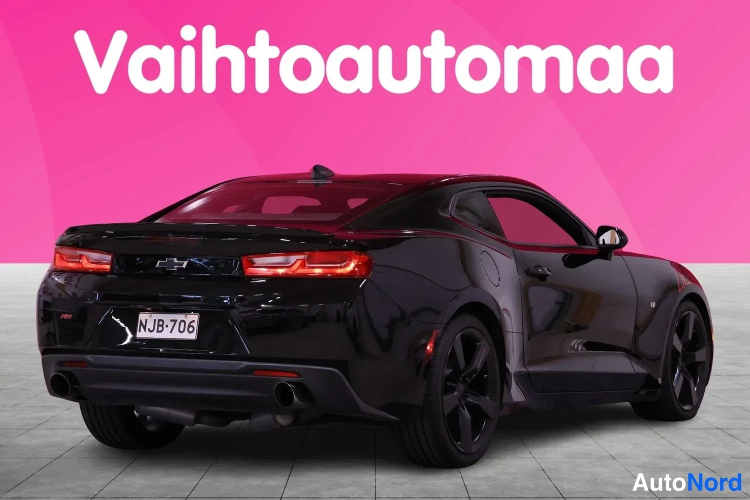 Takaviisto: Mustan Chevrolet Camaron taka-kolmasosa, takavalot syttyneinä, rekisteritunnus.