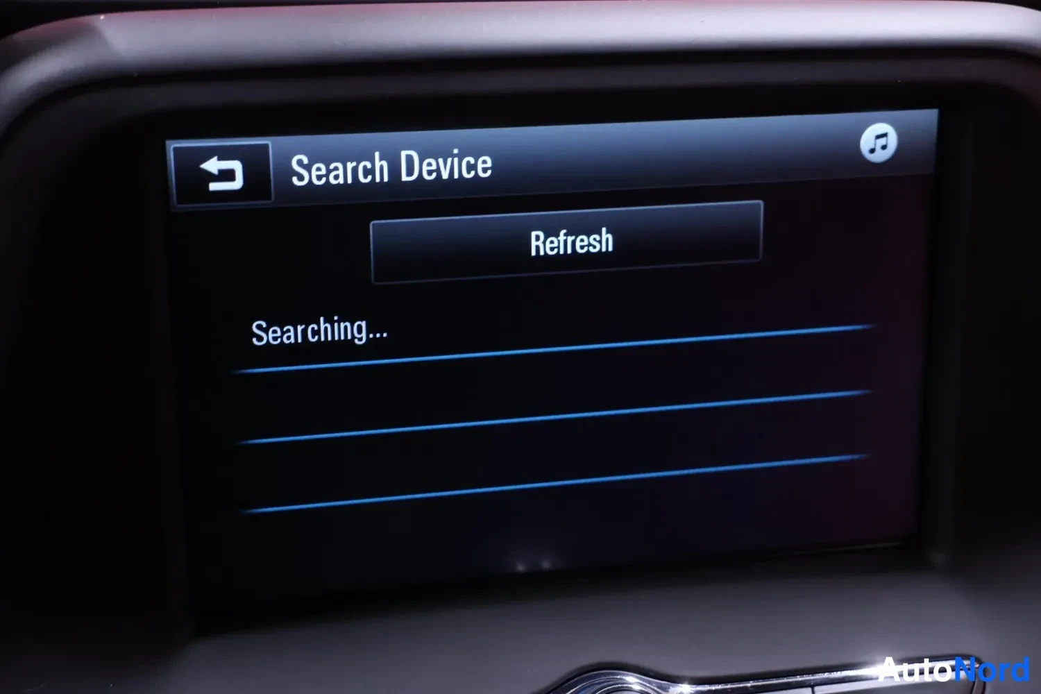 Yksityiskohta: Auton infotainment-näyttö, jossa on 'Search Device' -hakunäkymä, 'Refresh'-painike ja teksti 'Searching...'.