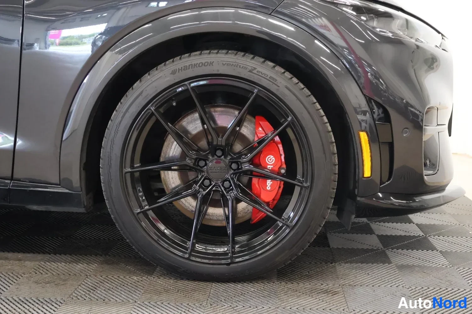 Yksityiskohta: Musta kevytmetallivannes jyrsinrenkaalla Hankook-rengas ja punainen Brembo-jarrusatula.