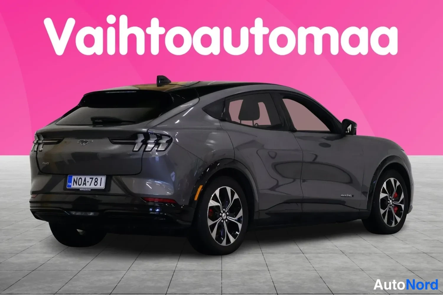 Takaviisto: Auto takaa neljänneskulmasta: harmaa Ford Mustang Mach-E, takavalojen ja rekisterikilven N0A-781 kanssa