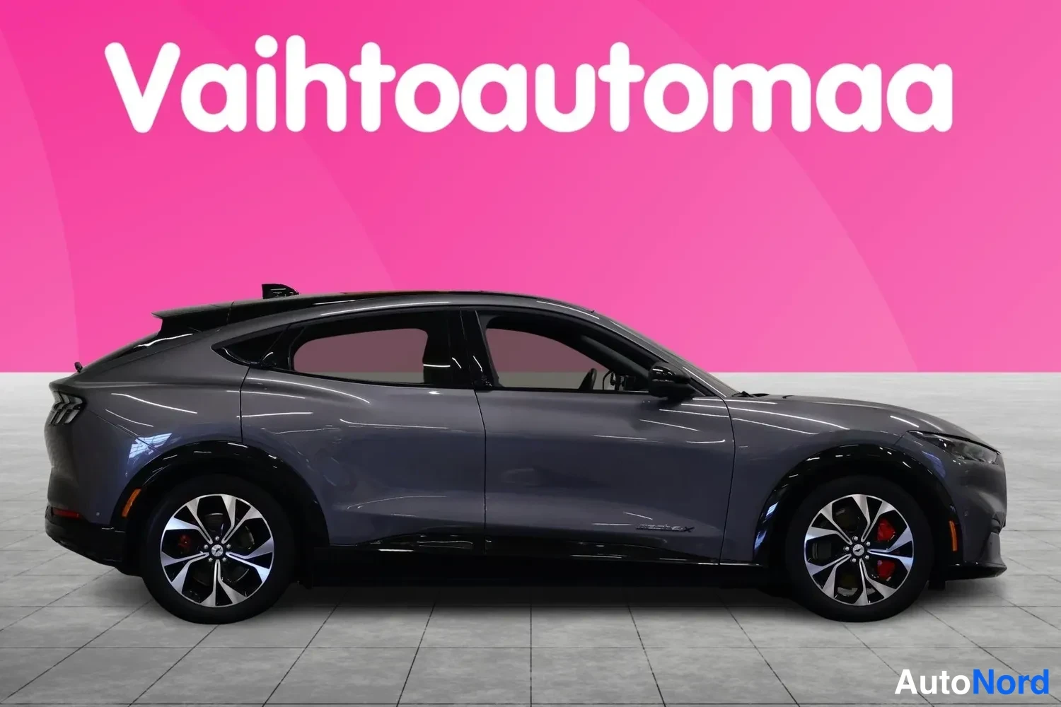 Sivulta: Auto sivusta: harmaan Ford Mustang Mach-E:n vasen kylki ja pyörät täydessä profilissa