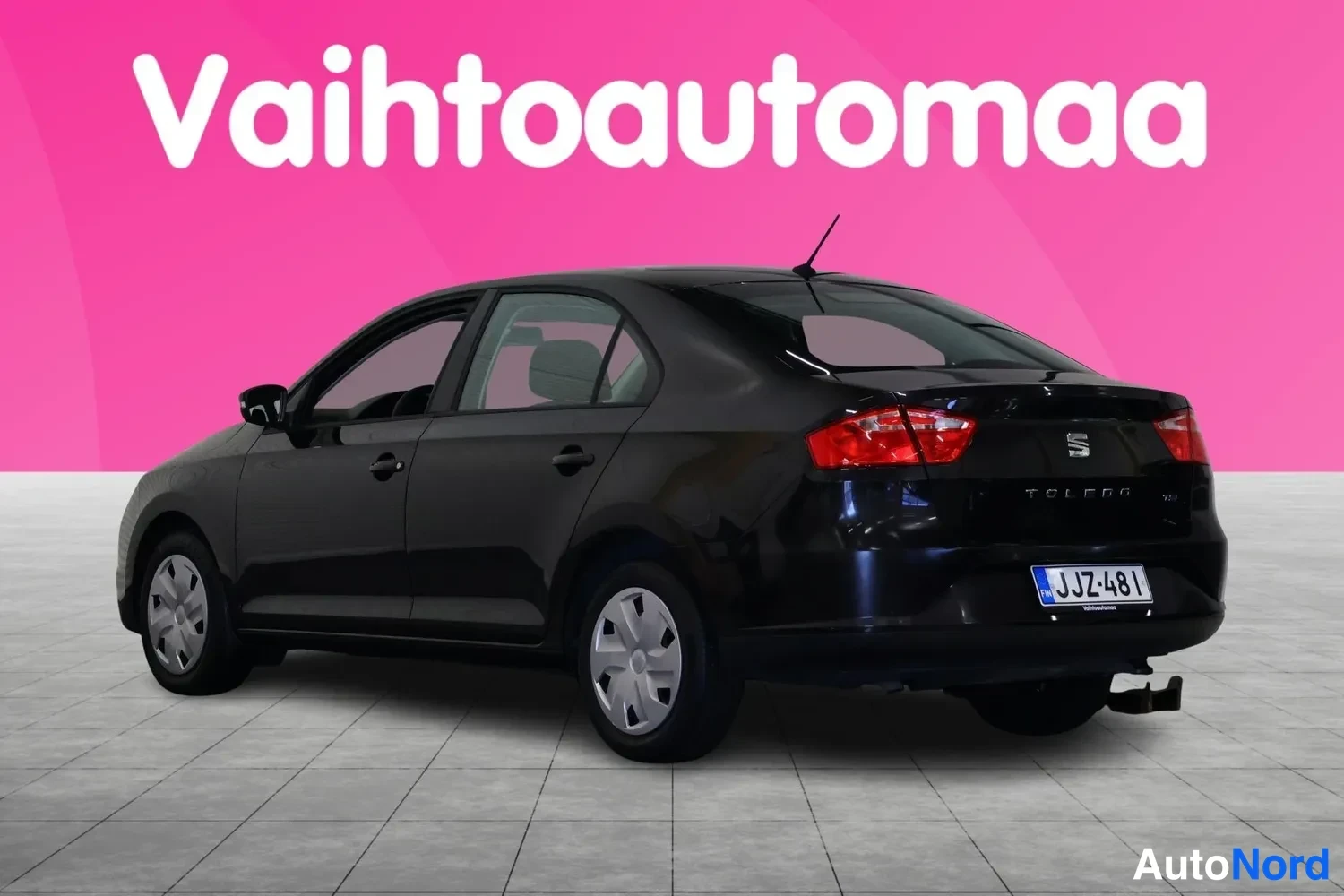 Takaviisto: Musta Seat Toledo takakenossa vasemmalle kuvatussa studioylevityksessä, rekisteritunnus.