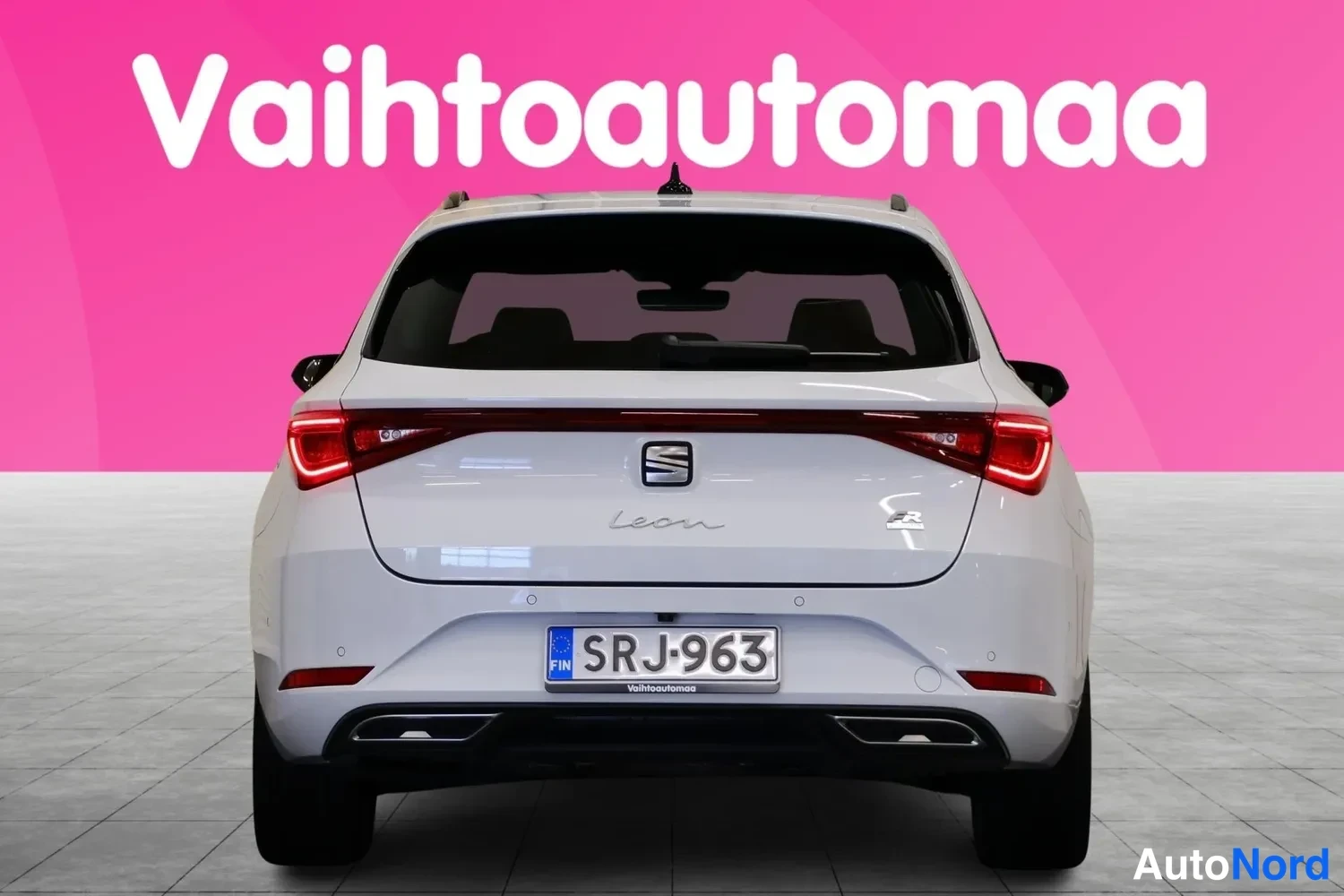 Takaa: Valkoinen Seat Leon takaapäin, rekisterikilpi, pinkki tausta