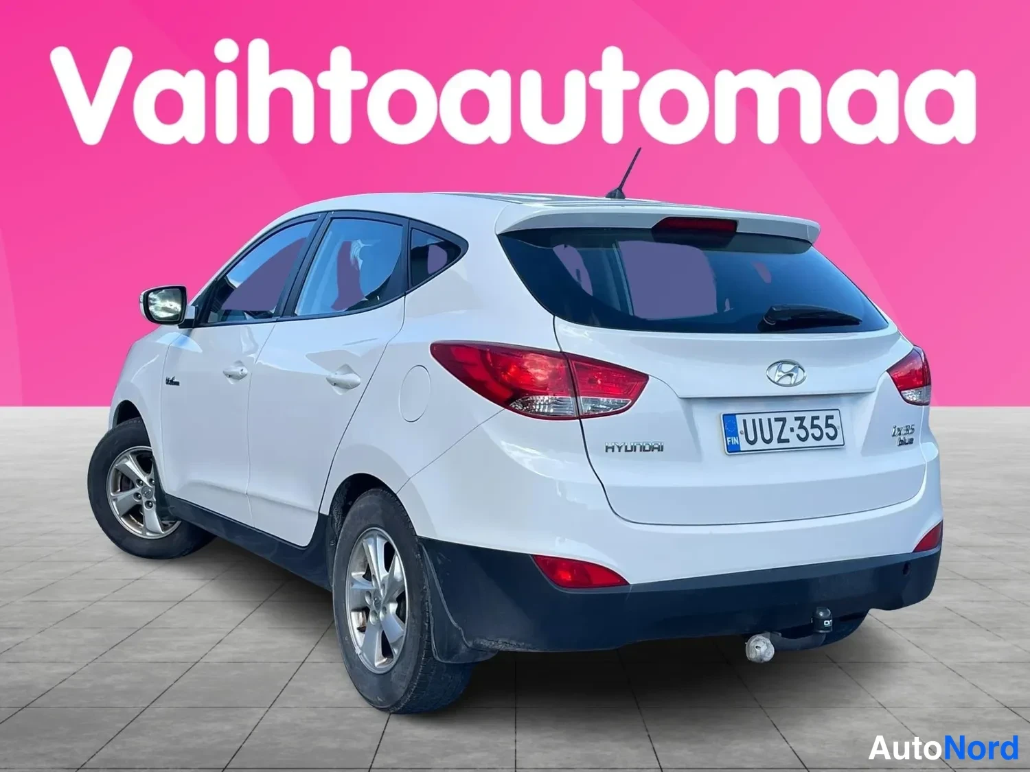 Takaviisto: Hyundai ix35, valkoinen, takanurkka vasemmalta; rekisteri, HYUNDAI-tunne, ajettava vaaleanpunainen tausta.