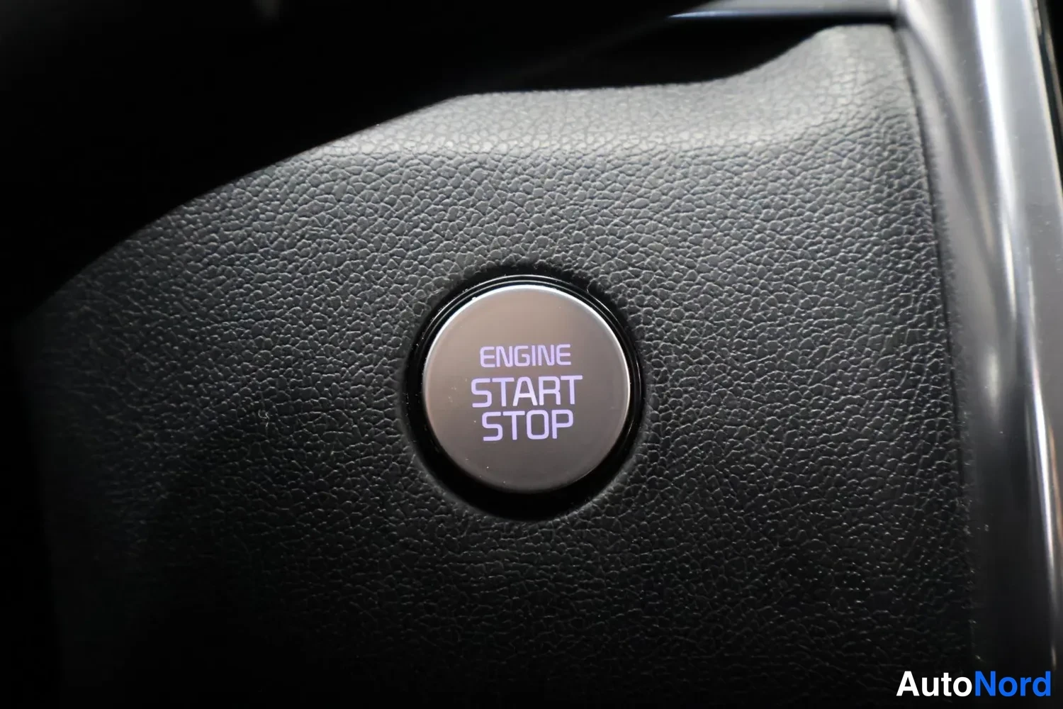 Muu: Ohjauspyörän keskustassa oleva käynnistyspainike, jonka tekstinä ENGINE START STOP.