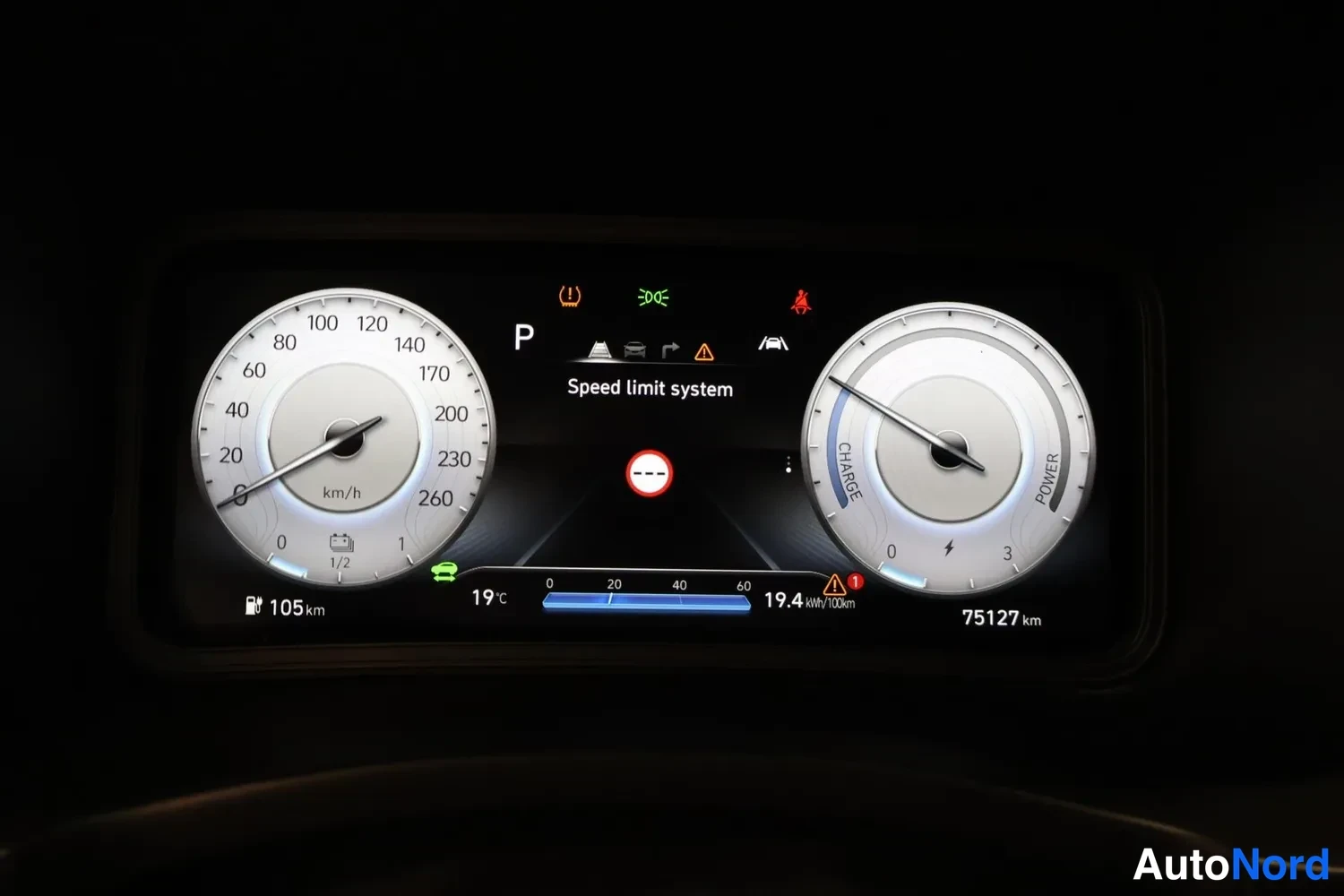 Muu: Kojetaulun näyttö P-asennossa: nopeusmittari, CHARGE/POWER-mittari, Speed limit system -teksti, 105 km riittää, 75127 km, 19,4 kWh/100 km.