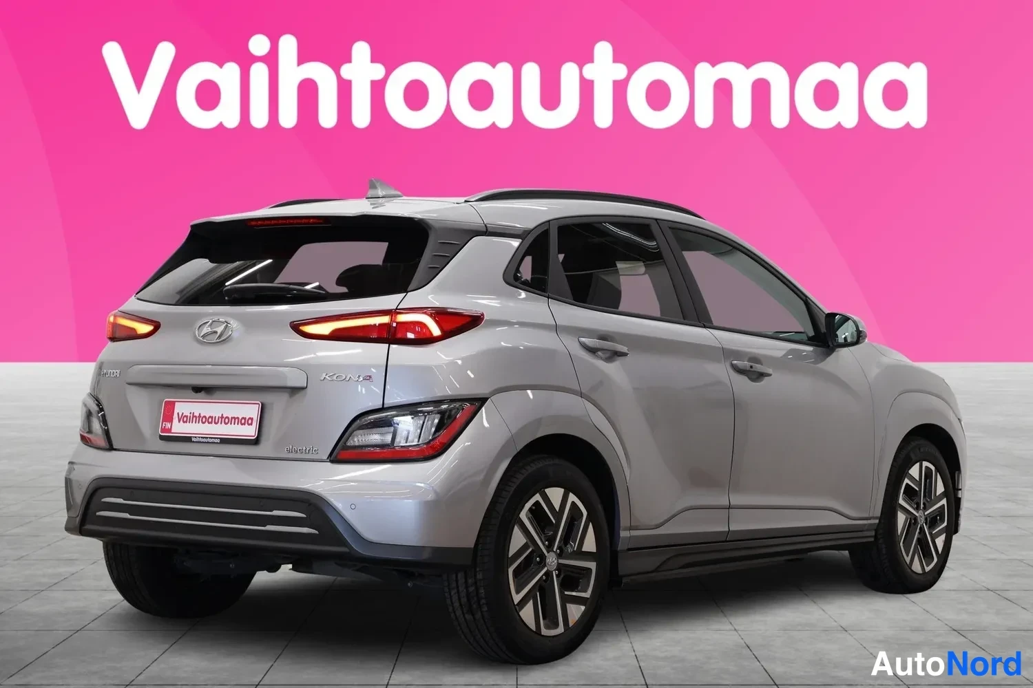 Takaviisto: Hopeanharmaa Hyundai Kona takaa oikealta kuvattuna, Kona Electric -merkinnät perällä.