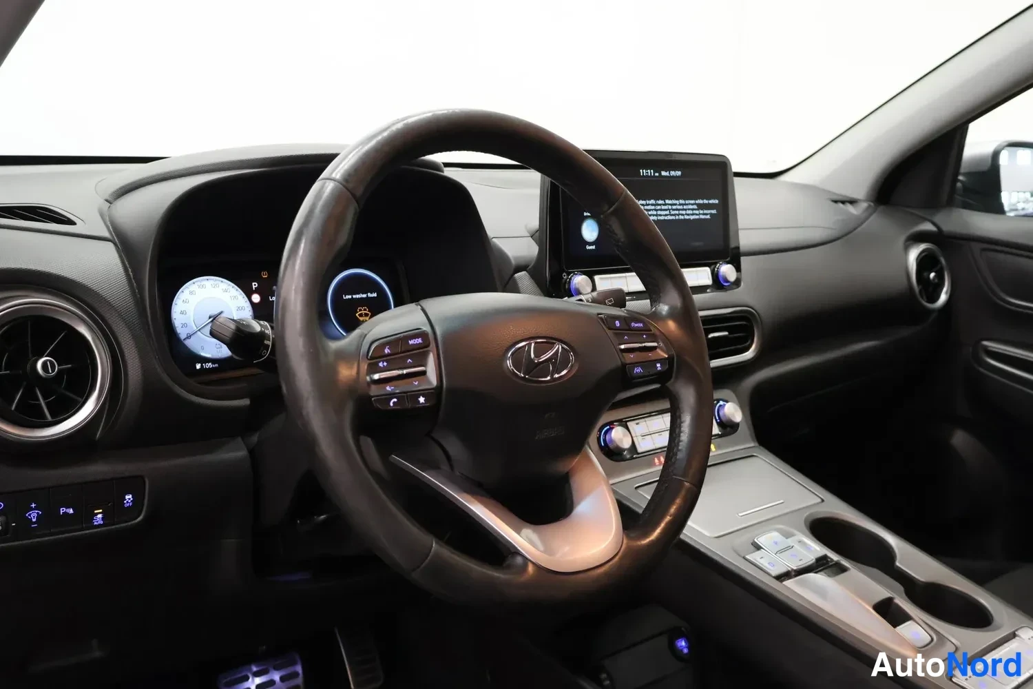 Sivulta: Kuljettajan näkymä Hyundai-ohjauspyörällä ja keskiö kosketusnäytöllä.
