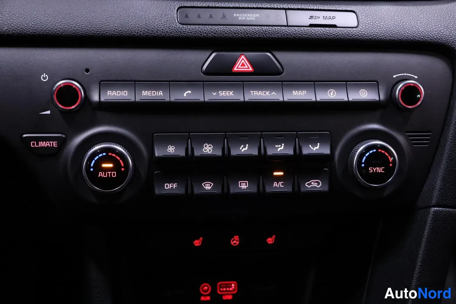 Yksityiskohta: Kesäkosoolin painikkeet ja automaattinen ilmastointipaneeli: RADIO-, MEDIA-, SEEK-, TRACK-, MAP-painikkeet sekä AUTO- ja SYNC-säätörataset, A/C ja OFF-painikkee